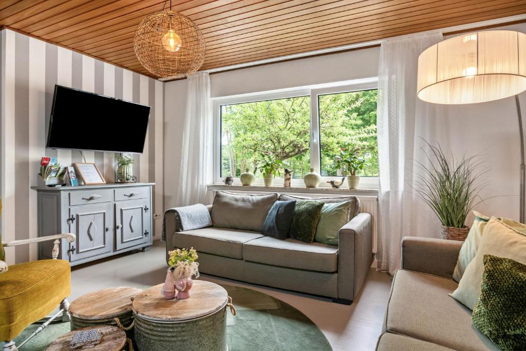 a living room with a couch and a tv at Eifelraum-Relaxwohnung mit Sauna in Oberbettingen