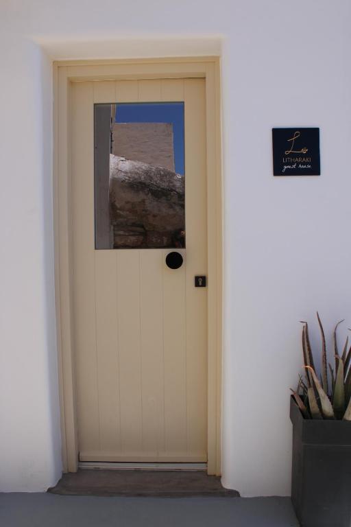 a white door in a white wall with a picture on it at Litharaki Guest House in Ano Syros