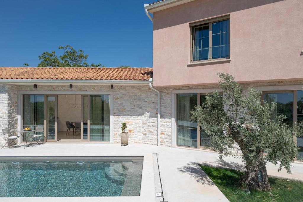 a house with a swimming pool in front of it at Villa Da Ella by IstriaLux in Krnica