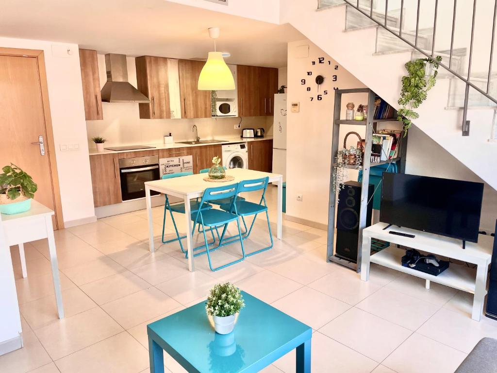 ein Wohnzimmer mit einem Tisch und einer Küche in der Unterkunft Duplex RIO EBRO in Deltebre