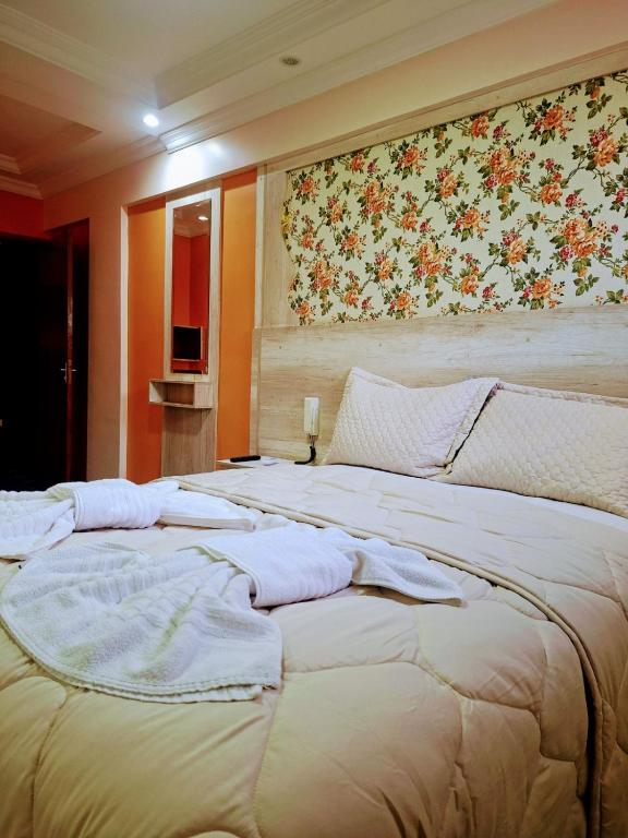 a bedroom with a large bed with towels on it at Arion Hotel Sapopemba in São Paulo