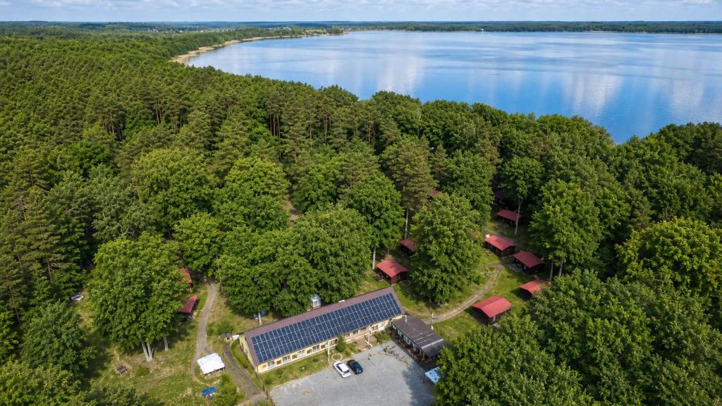 an aerial view of a building in a forest next to a lake at Natura Ferienpark - Bungalows am Grimnitzsee Schorfheide in Althüttendorf