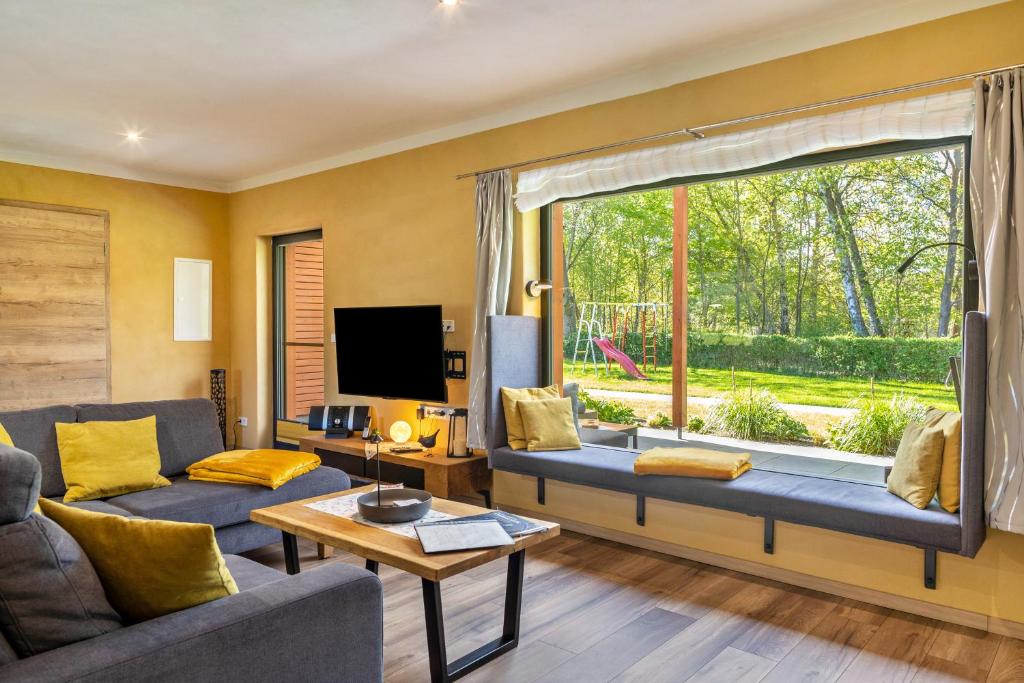a living room with a couch and a large window at Ferienhaus Milchstraße mit Sternenblick in Lochow