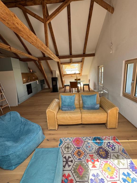 a living room with two couches and a table at Dachboden Loft in Laax