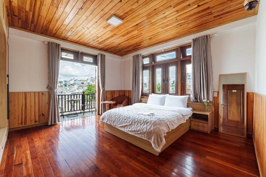 a bedroom with a bed with a wooden ceiling at AT House Dalat - The Pine Concept in Da Lat