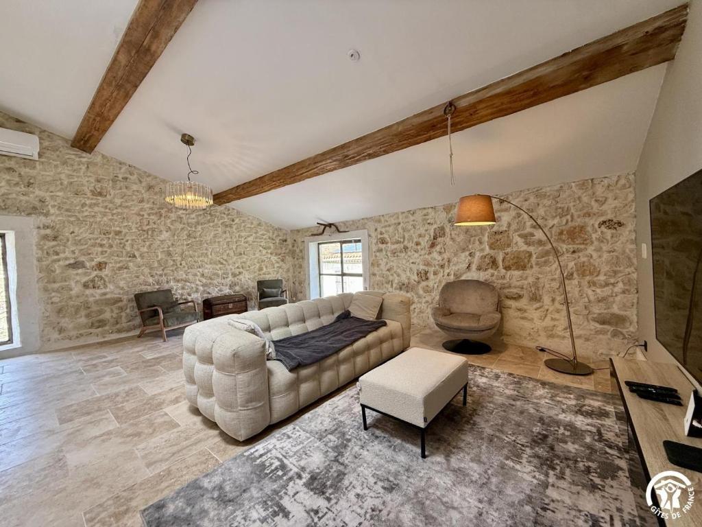 a living room with a couch and a table at Le gîte du clos in Roquefort-des-Corbières