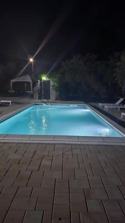 a blue swimming pool at night with a light at Villa DARIAN in Sukošan