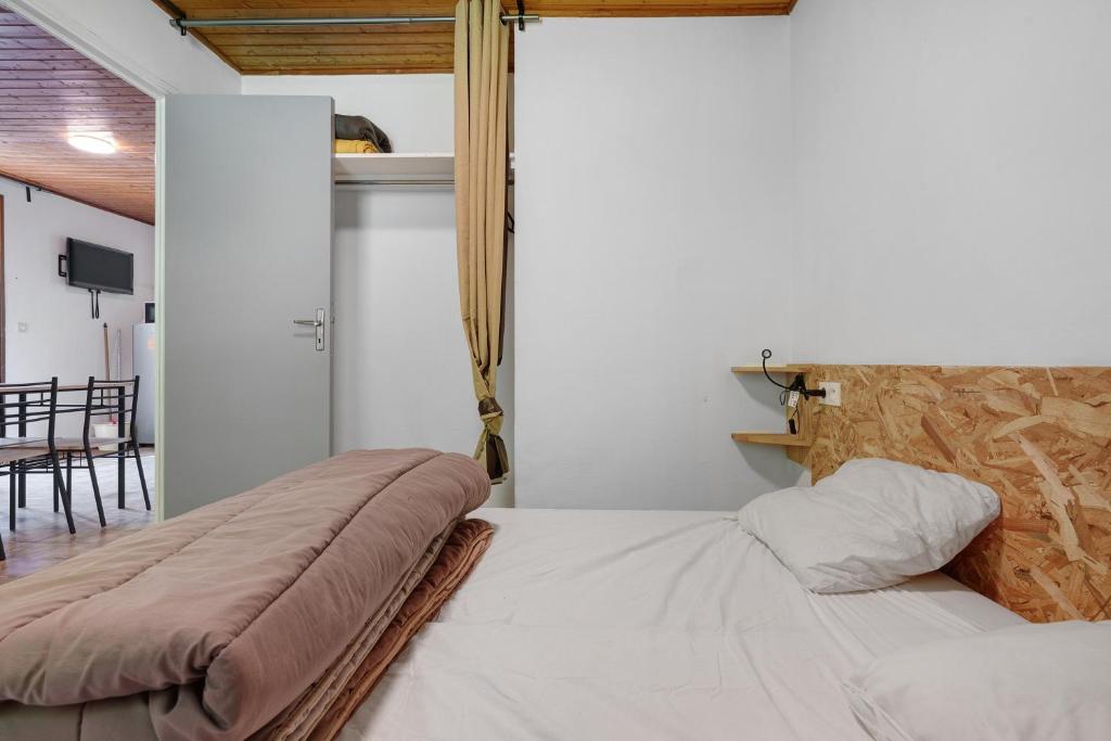 a bedroom with a bed with a blanket on it at 8.Les papillons option clim-4 pers in Calviac