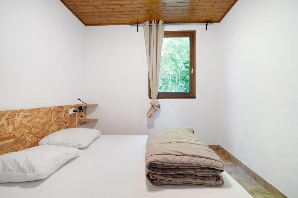a bedroom with two beds and a window at 6.hirondelles Option Clim- 4 pers in Calviac