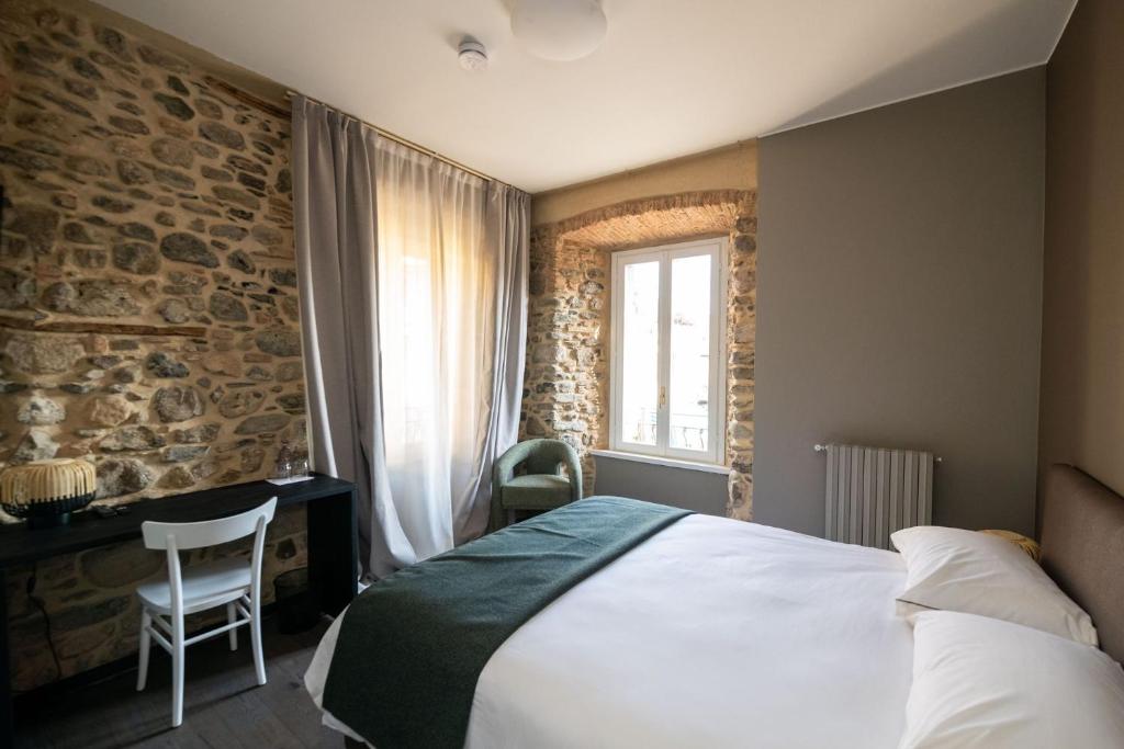 a bedroom with a bed and a desk and a window at Albergo Canzo in Canzo