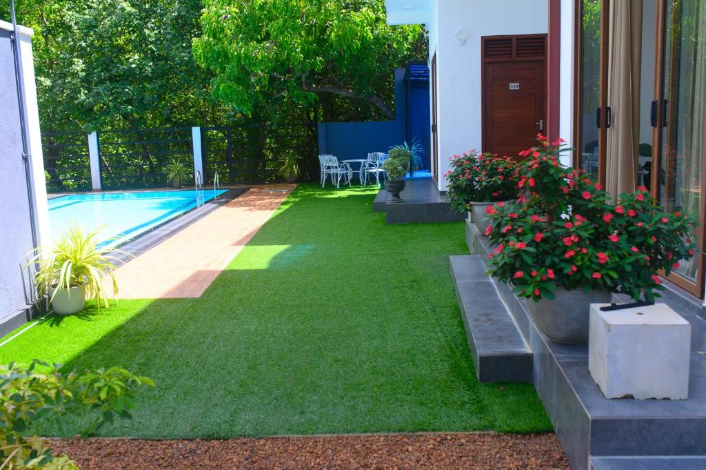a yard with a swimming pool and some plants at Madu Rivora Villa in Ambalangoda