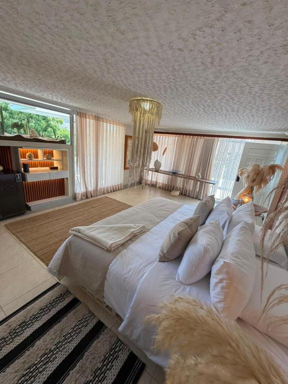 a large bedroom with a large white bed with pillows at Casa Elixir Boutique in Barranquilla