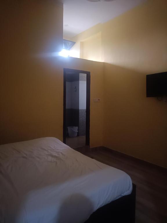 a bedroom with a bed and a light on the wall at Shivalik restaurent and hotel in Kālādhūngi