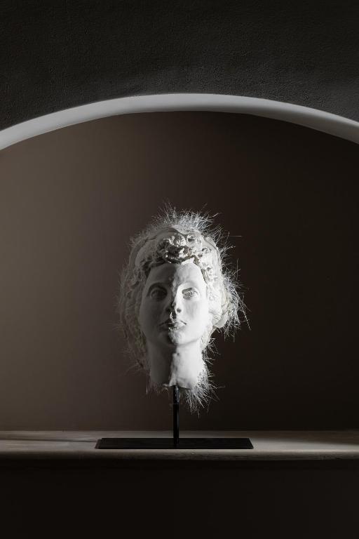 a statue of a bust of a woman with curly hair at Palazzo Settanta in Catania