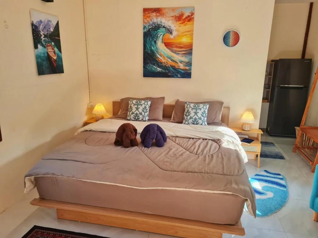 a bedroom with a large bed with two stuffed animals on it at Blue Cottage Koh Kood a Quiet Tropical Getaway in Ban Lak Uan