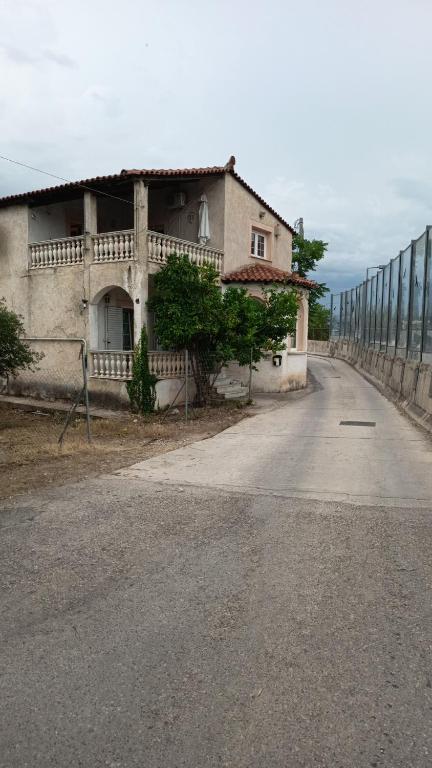 a house on the side of a road next to a fence at Rooms renovated climate 200 meter from metro Pallini 20 min with train and bus 24 hours please don't read anything just stay in Pallini