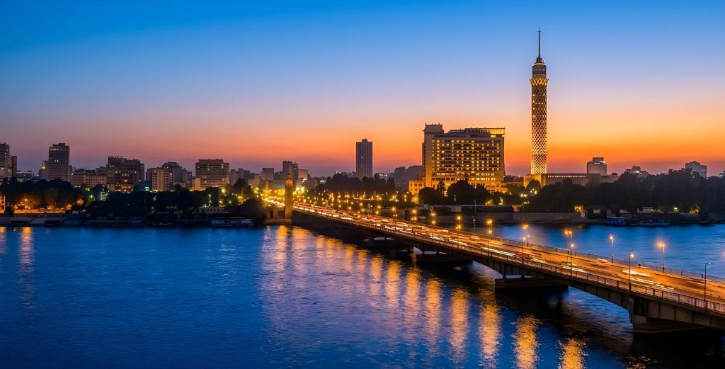 a bridge over a river with a city at sunset at Garden El Tahrir Downtown Hotel in Cairo