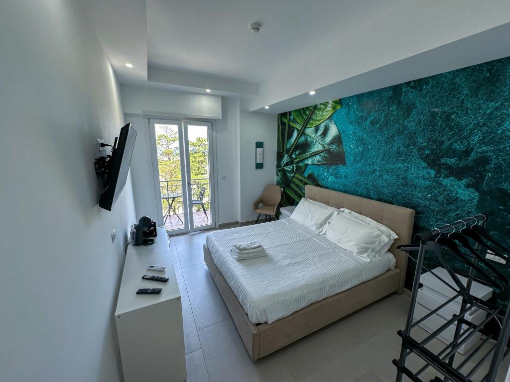 a bedroom with a large painting on the wall at Beach House - Affittacamere Paola in Paola