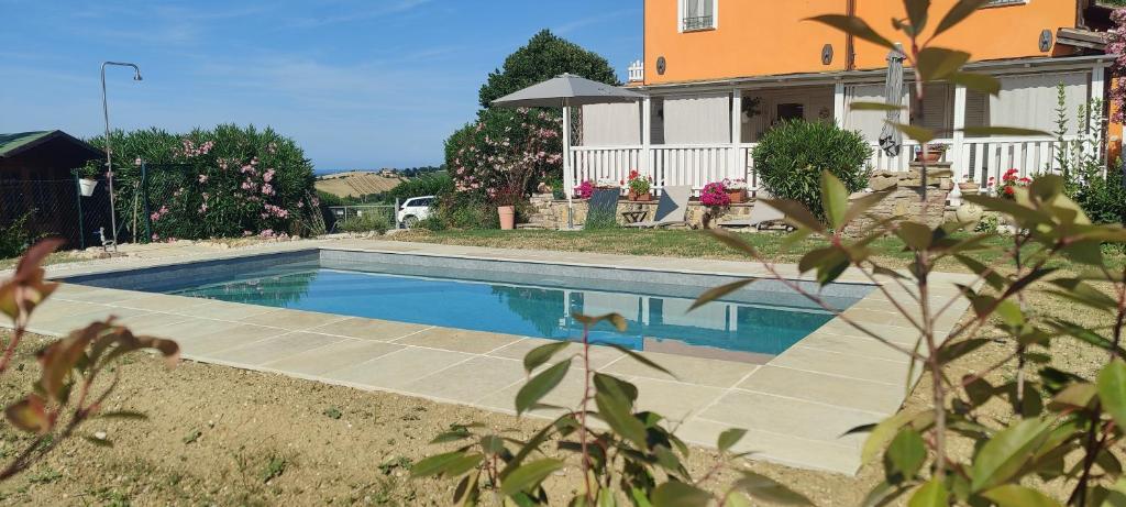 a swimming pool in front of a house at Joka B&B e Home Food in Potenza Picena