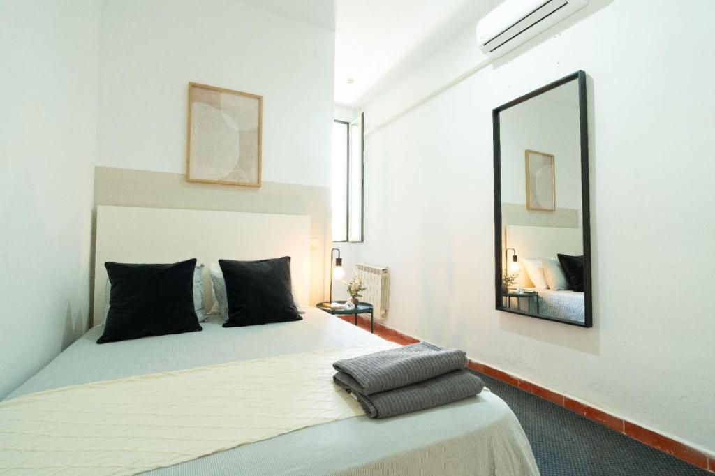 a bedroom with a large bed with a large mirror at Magdalena2 Street, Private rooms in Madrid