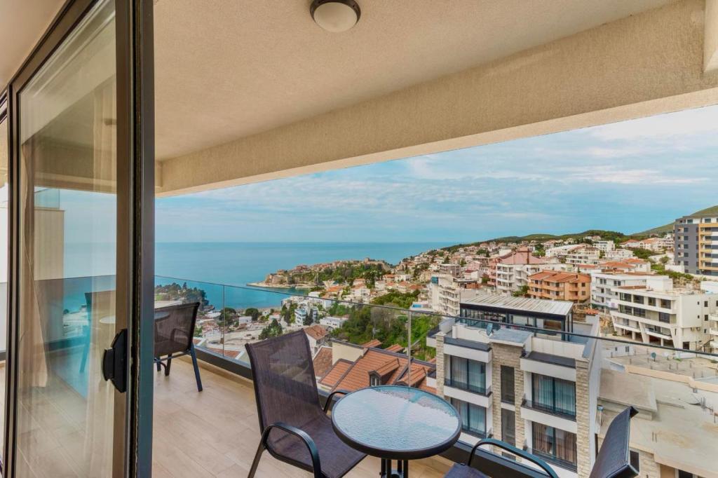 a balcony with a table and chairs and a view of the ocean at Hotel Ulliri & SPA-KASMI in Ulcinj