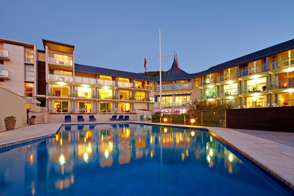 a hotel with a swimming pool in front of a building at Picton Yacht Club Hotel in Picton