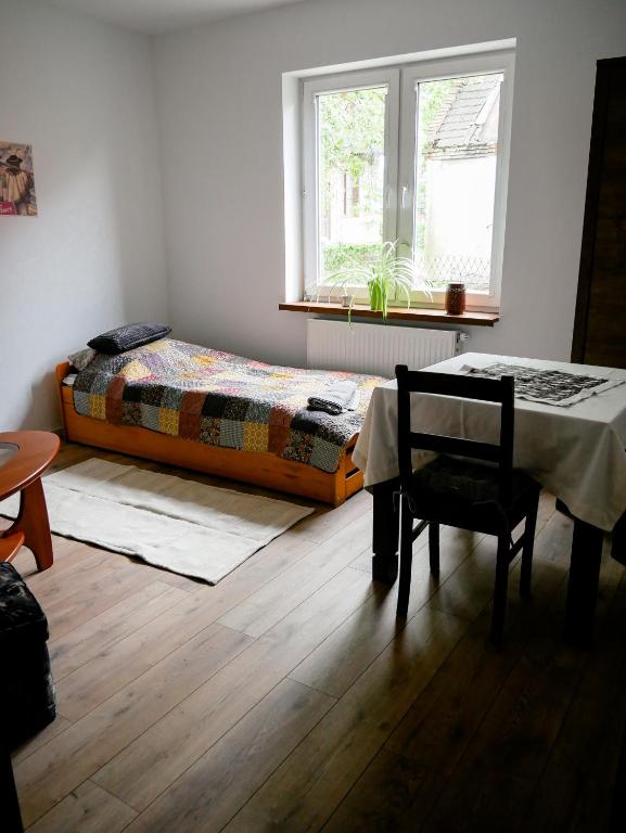 a bedroom with a bed and a table and a window at Dom jednorodzinny NOWA in Dęblin
