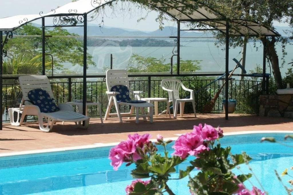 a group of chairs sitting next to a swimming pool at Casa Vista Lago 154 SQM in Passignano sul Trasimeno