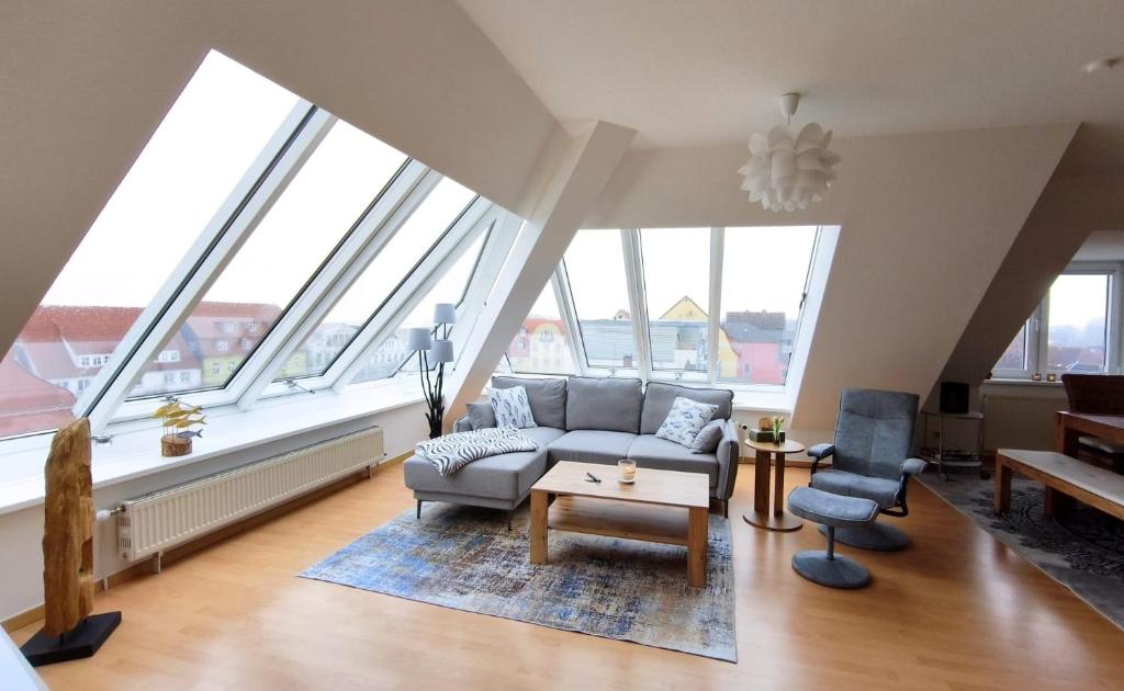 a living room with a couch and chairs and windows at Traumblick Barth - Boddenblick, Tiefgarage & Aufzug in Barth