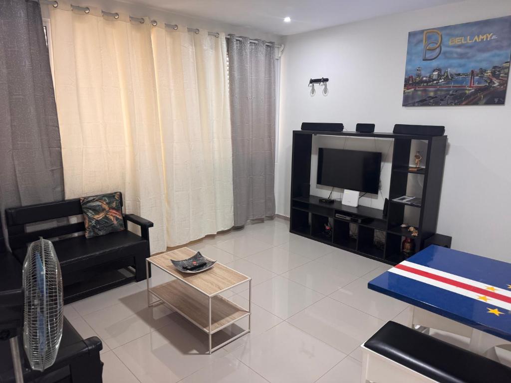 a living room with a couch and a tv at Bellamy in Porto Novo