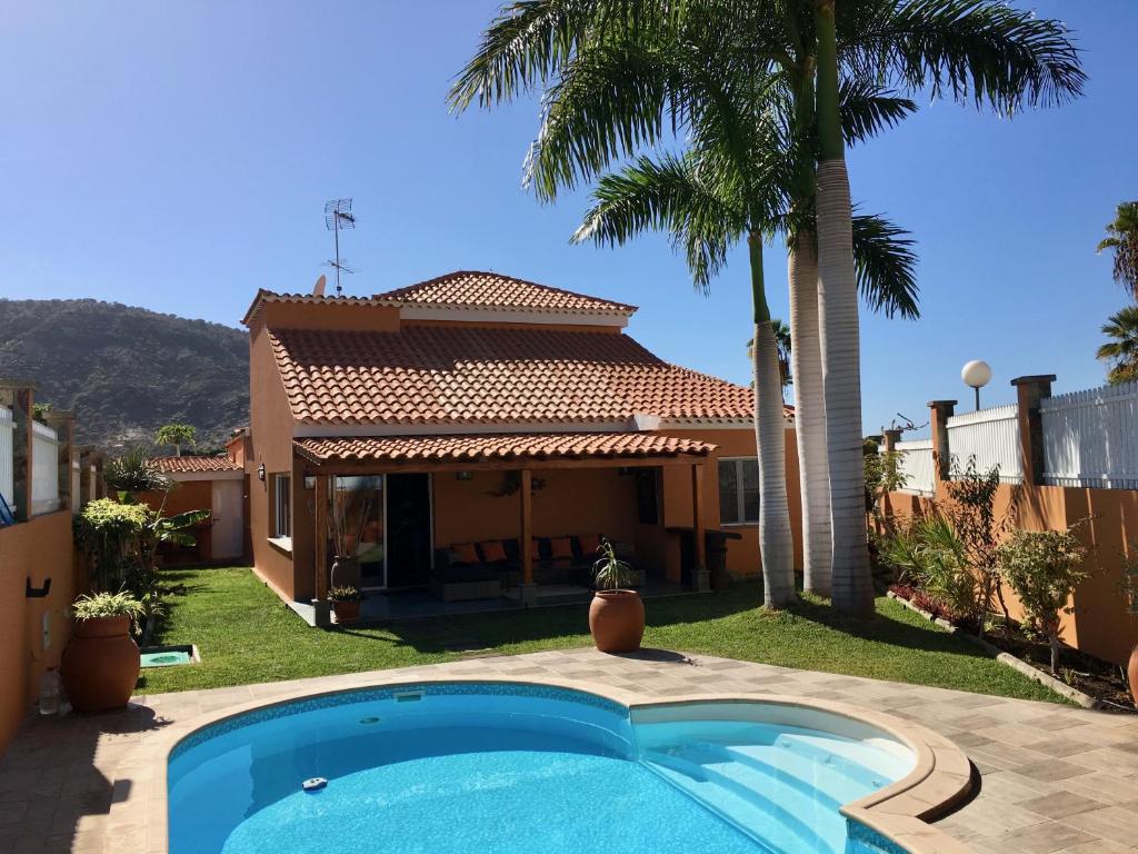 una casa con piscina y una palmera en Villa Tauro Country Club, en La Playa de Tauro