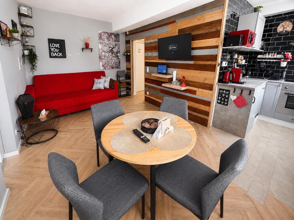 a living room with a table and chairs and a red couch at Sweet Home in Klagenfurt