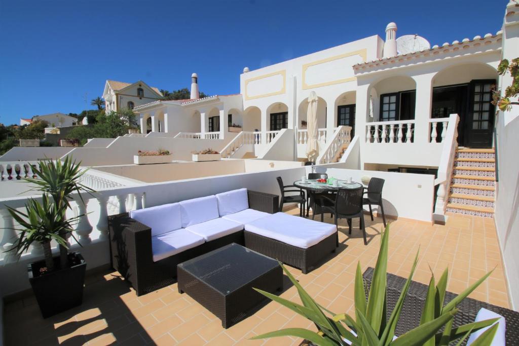 a patio with a couch and a table and chairs at Charming Vila Van Gogh in Luz
