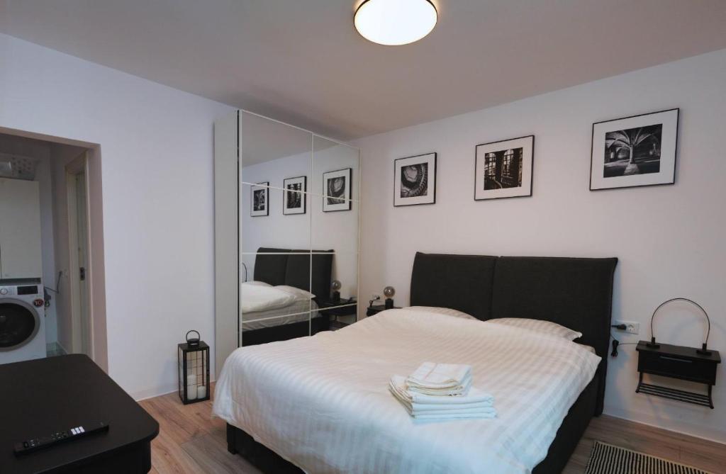 a bedroom with a white bed with a mirror at Skylark Apartments in Râmnicu Vâlcea