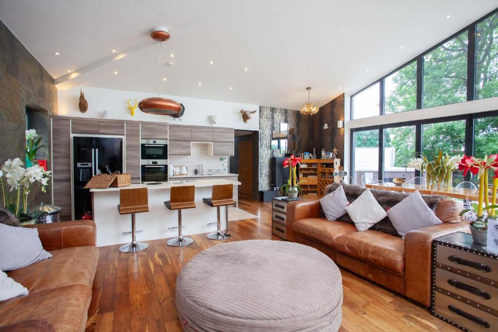 a large living room with a couch and a kitchen at Cameron North Lodge in Balloch