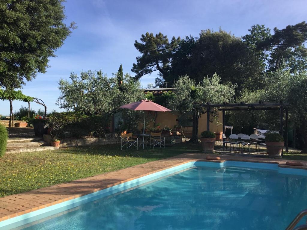 a swimming pool in a yard with an umbrella at Chalet fronte piscina in Zambra