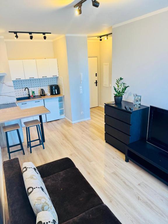 a living room with a couch and a kitchen at Zaczarowana Rotmanka in Rotmanka