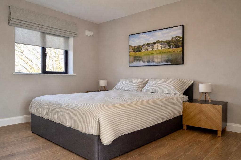 a bedroom with a large bed and two windows at Hawthorn Stays in Maynooth