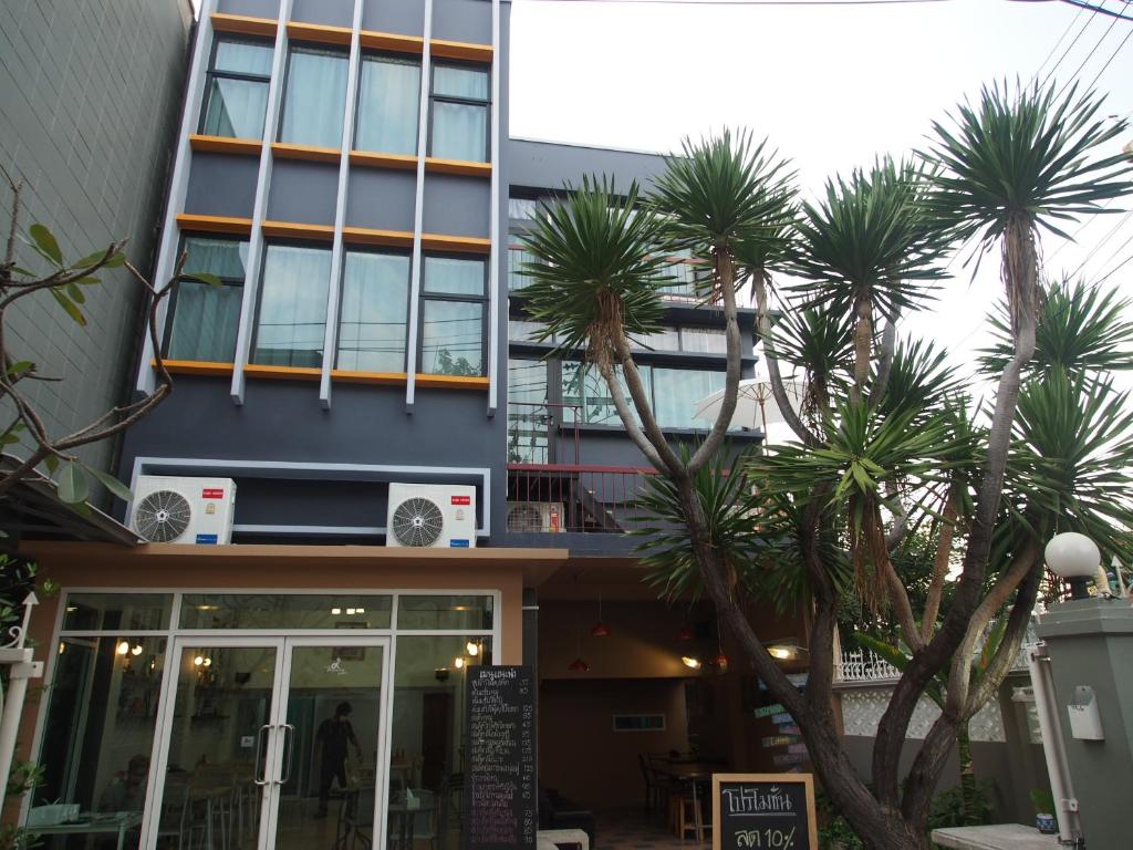 a building with palm trees in front of it at Sriyanar Place in Bangkok