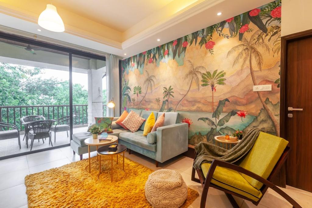 a living room with a couch and a mural at Deshco Oasis Suites, Alibaug in Chorondpāda
