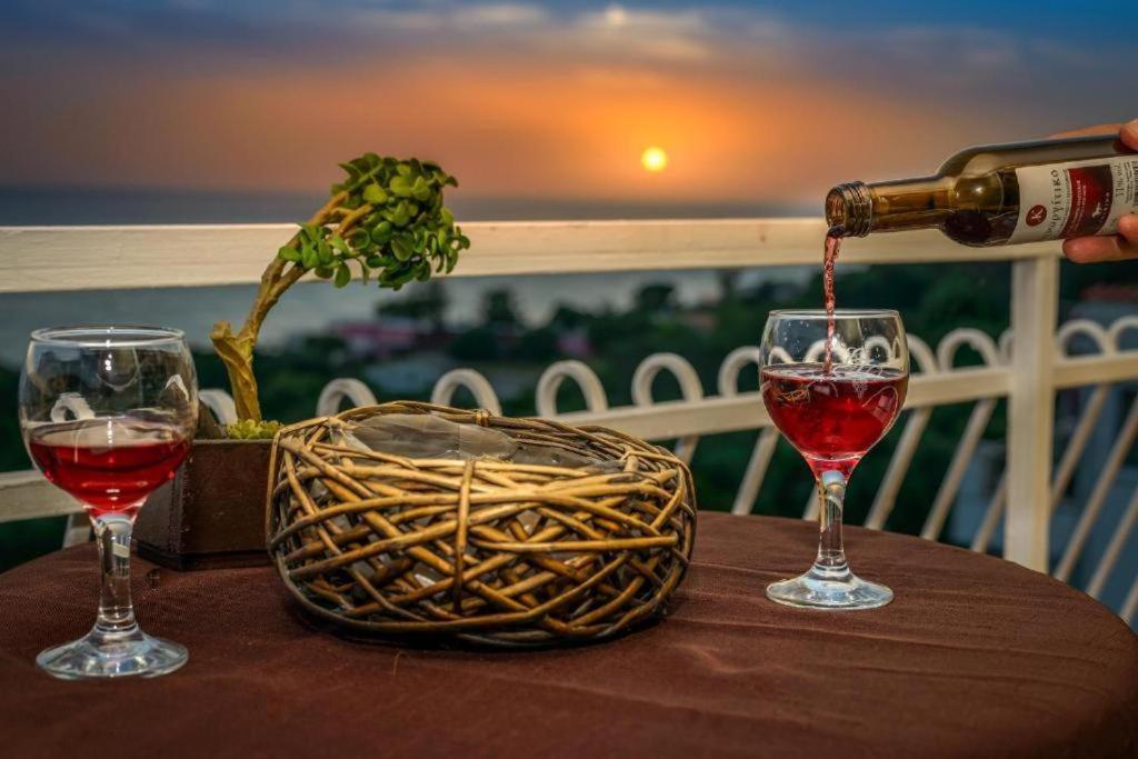 a bottle of wine being poured into two glasses on a table at Beach Oasis by BS- in Agios Gordios