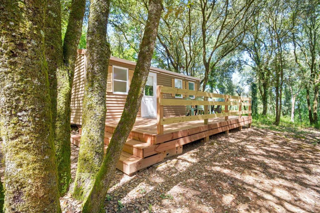 a log cabin in the woods with trees at 22.Mobil-home option clim 5pers in Calviac