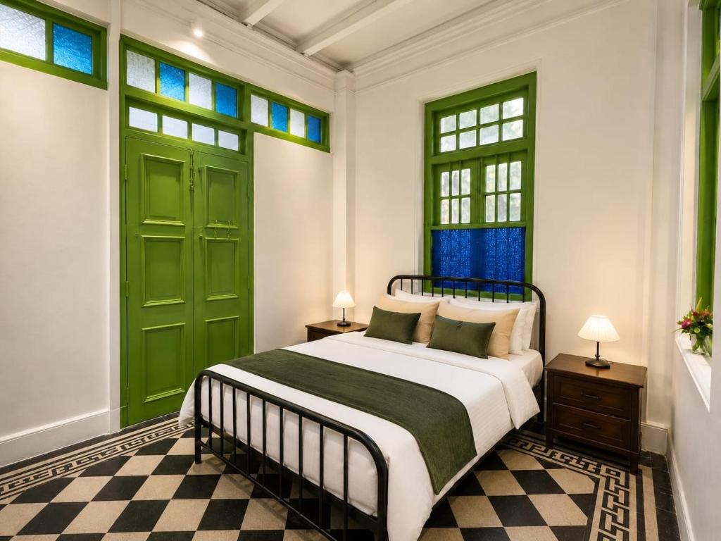 a bedroom with a bed with green doors and windows at Arvena Living in Jelutong