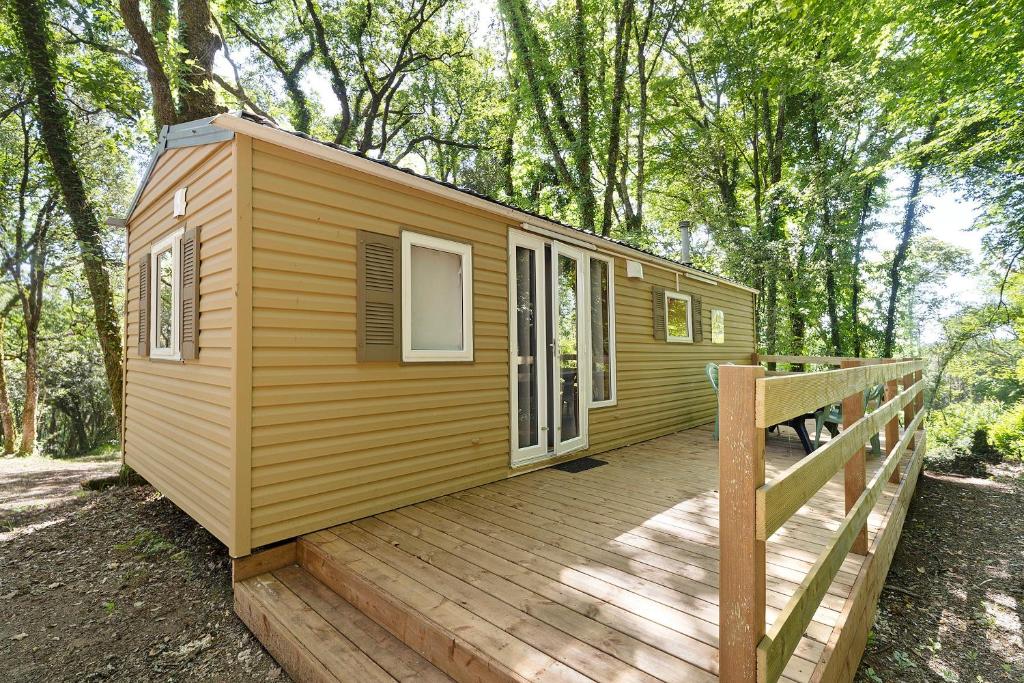a tiny house on a wooden deck in the woods at 21.Mobil-home option clim-5 pers in Calviac