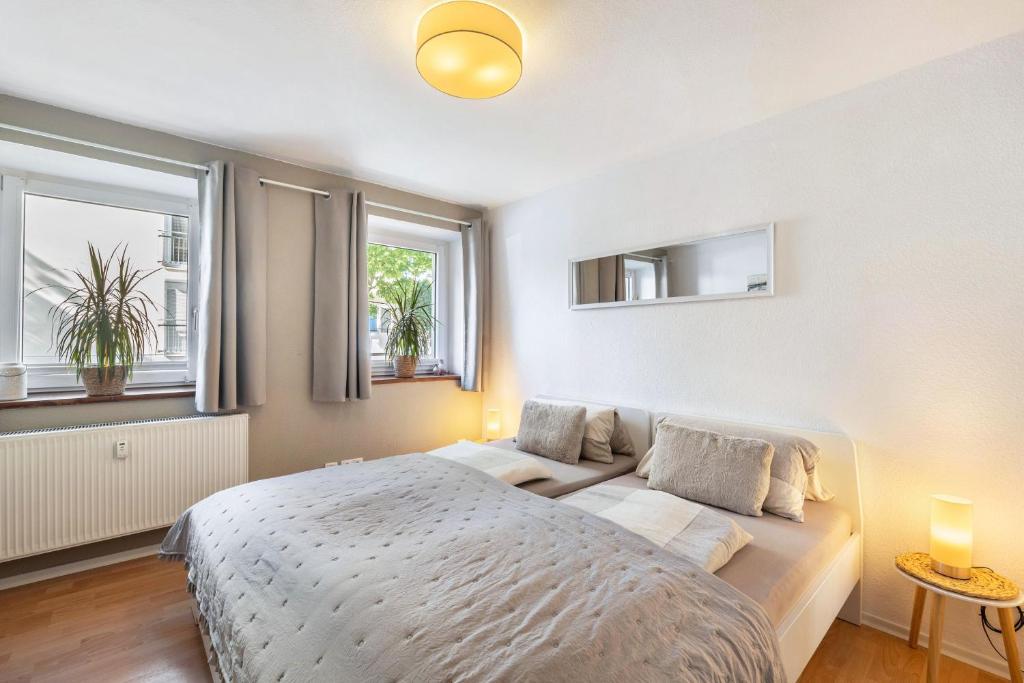 a bedroom with a bed and two windows at Fewo in der Altstadt - Enz in Bietigheim-Bissingen