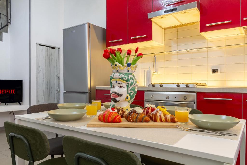 a table with a plate of food and a vase with a mask at In Centro a Rho Fiera Milano e Ospedale Galeazzi in Rho