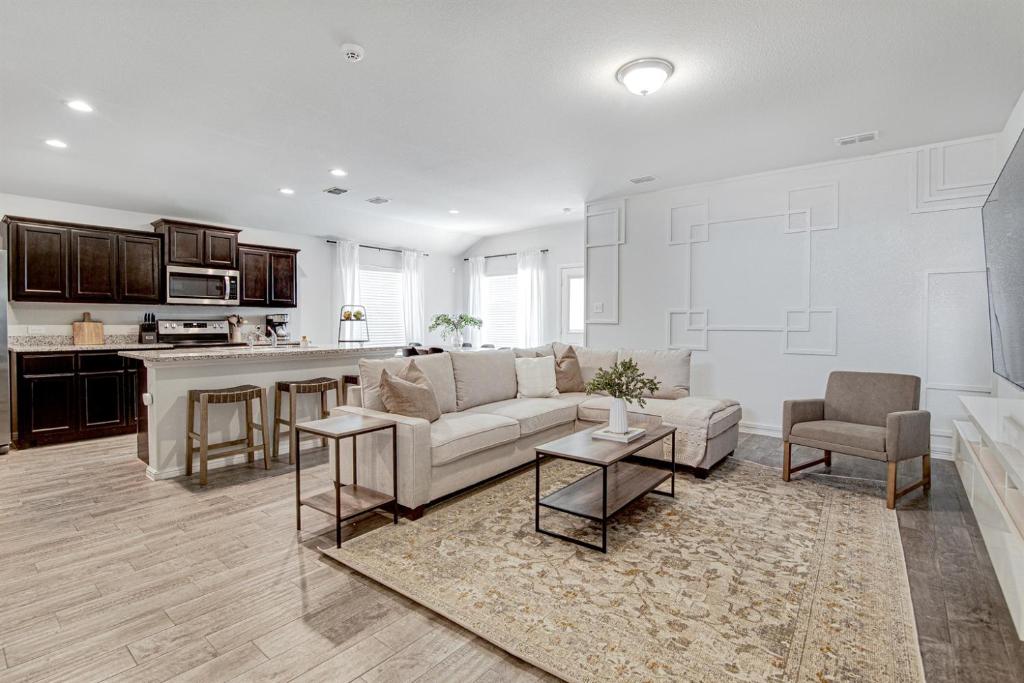a living room with a couch and a kitchen at A Serene Oasis! 4-bedrooms! in Saginaw