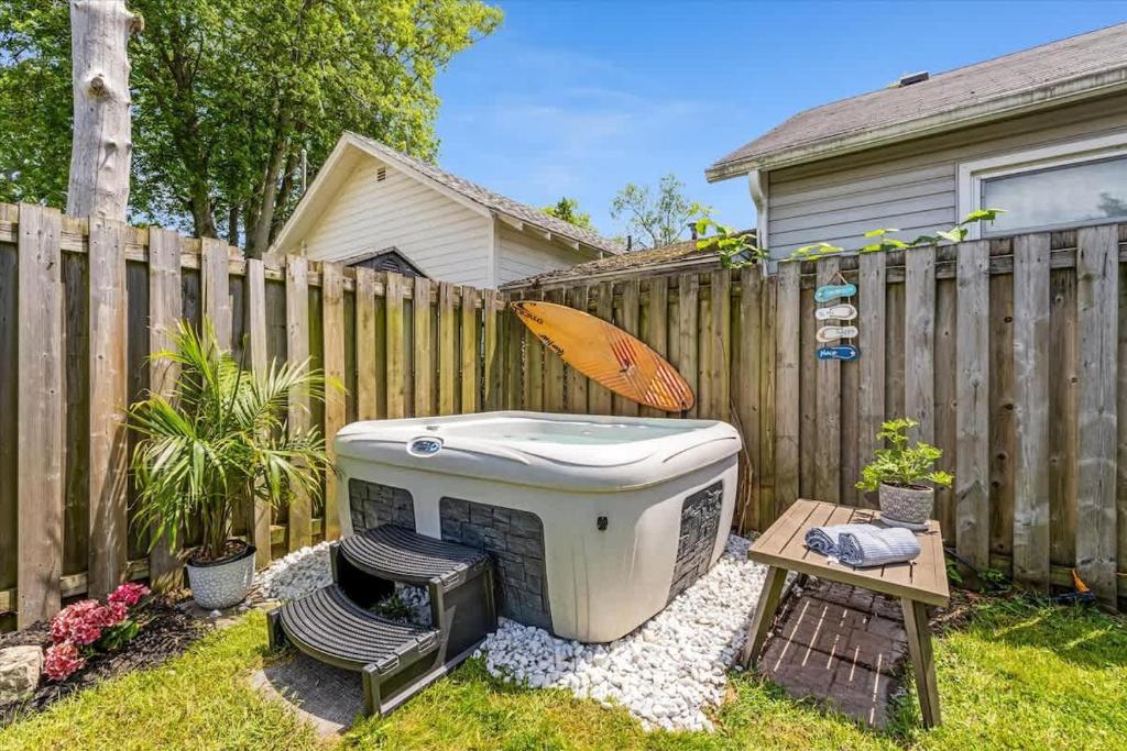 a backyard with a hot tub next to a fence at Fall Getaway|Crystal Beach Passes|Hottub|FirePit in Fort Erie