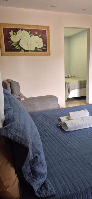 a bedroom with a large bed with a blue comforter at Aconchego IV in Miguel Pereira