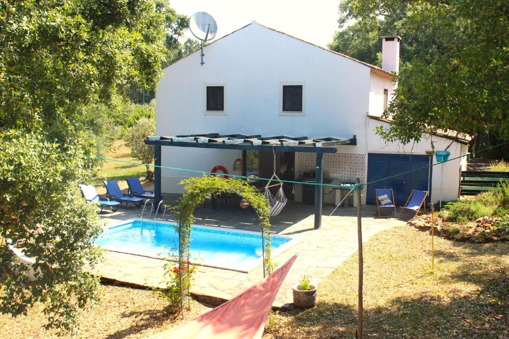 a house with a swimming pool in front of it at Casa dos Cavalos in Sertã